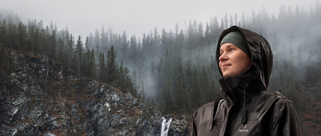 a man wearing a hoodie and standing on a snowy hill
