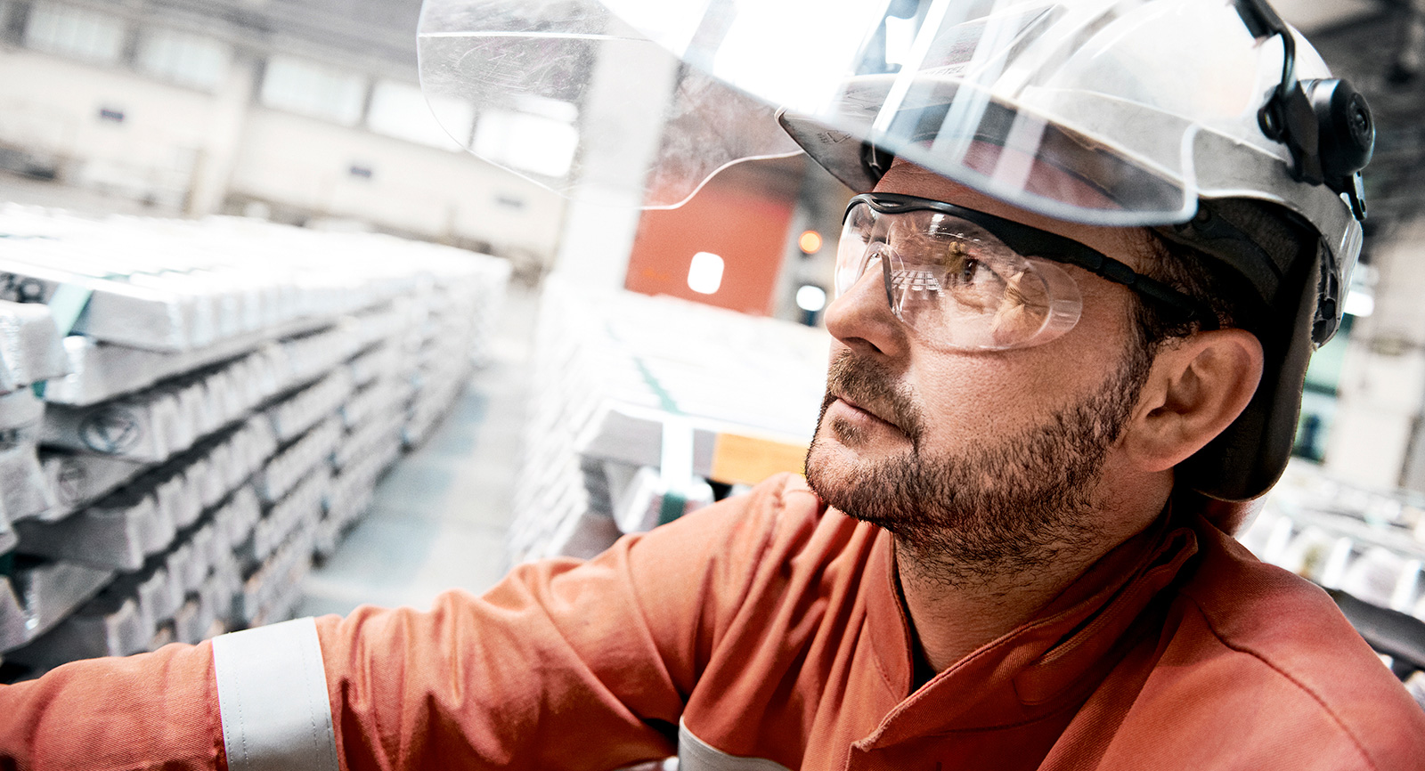 worker with stacks of aluminum bars