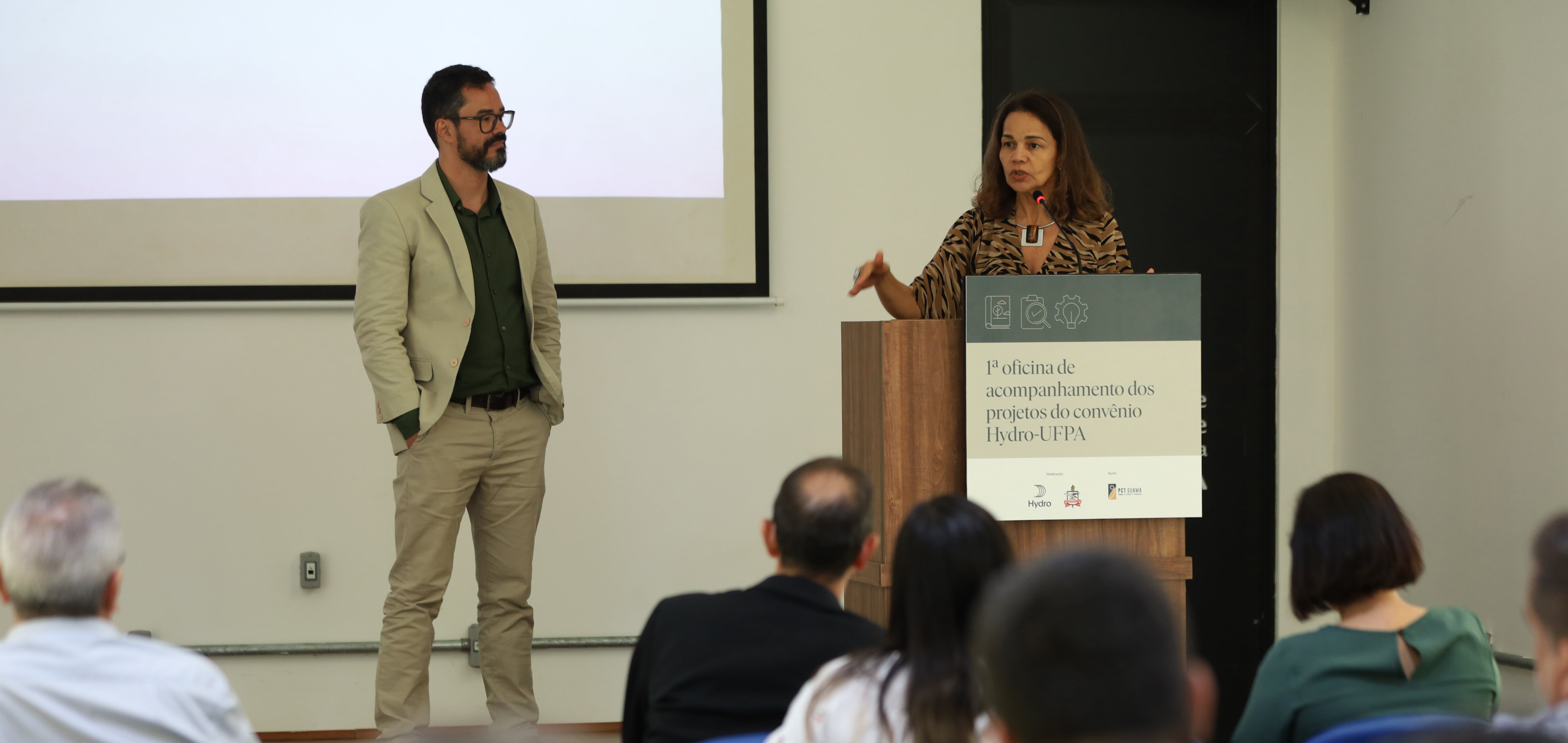 a man and woman standing in front of a group of people