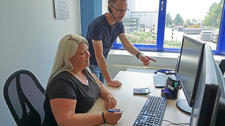 a man and a woman looking at a computer screen